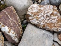 Weiße Maserungen und Einschlüsse in rötlichem und hellbraunen Stein